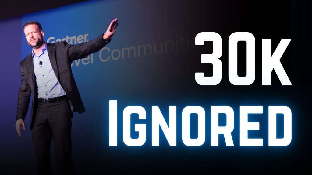 Executive speaker engaging an audience from a conference stage instead of reading slides